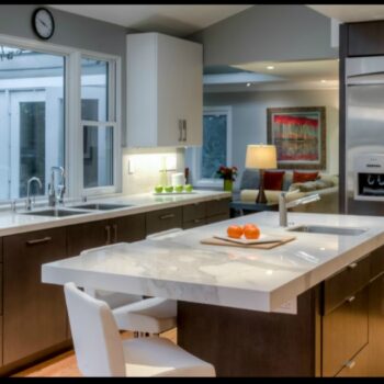 Gilmans Kitchens and Baths Dark Kitchen Cabinetry and White Granite Countertop
